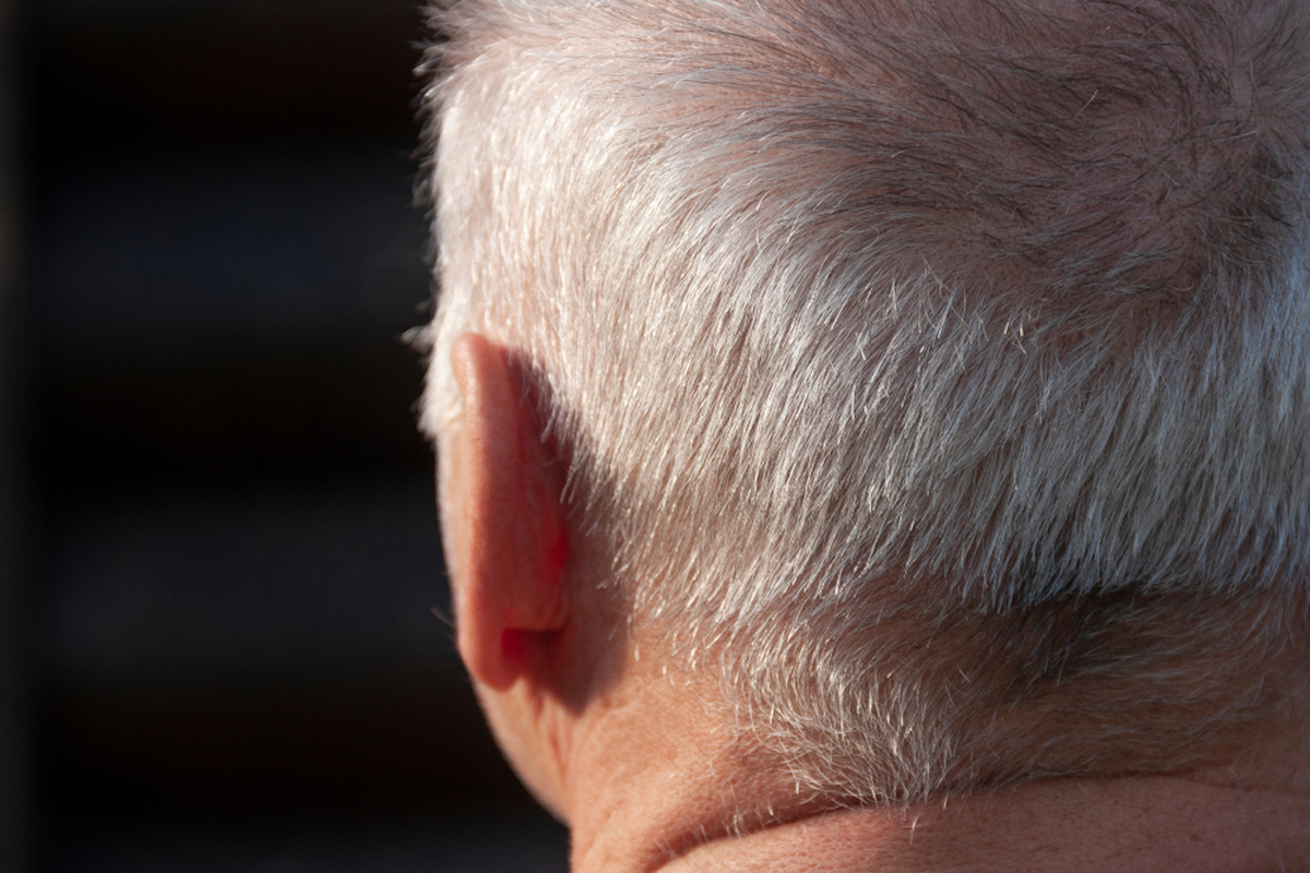 old man photographed from behind, focus is on ear