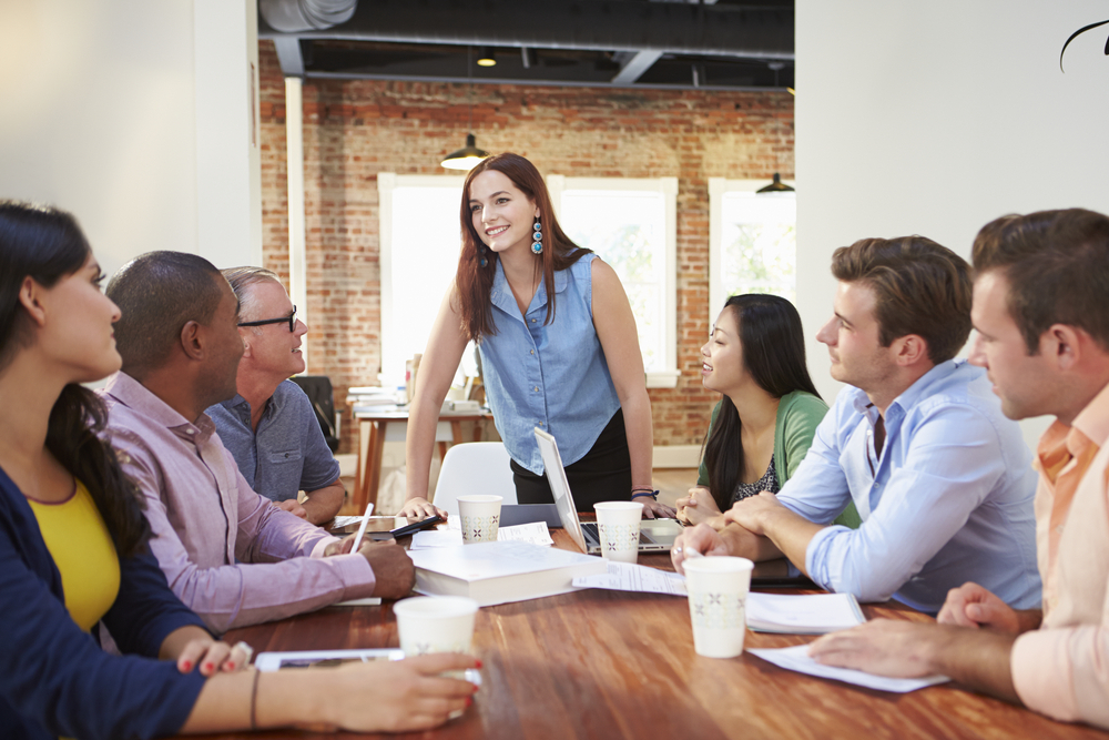 Woman speaking to colleagues in the office.
