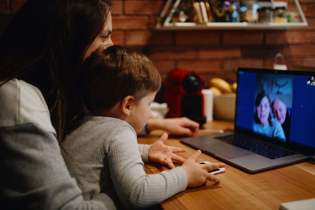 Grandparents in quarantine at home having video call with grandson and daughter