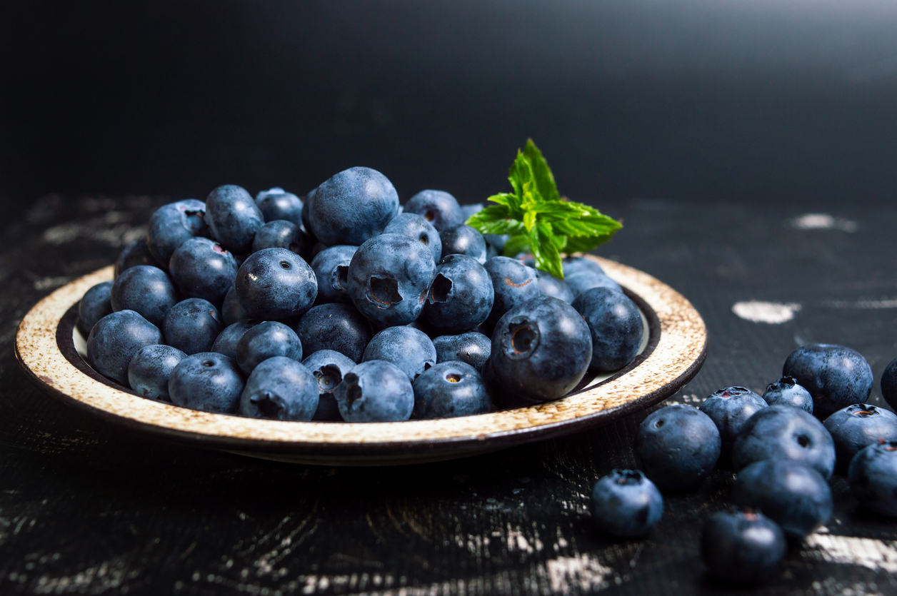 A wooden bowl filled with blueberries