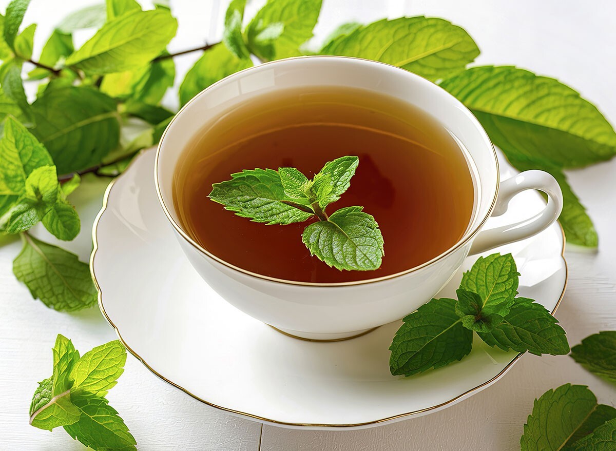 A tea cup of peppermint tea and mint leaves