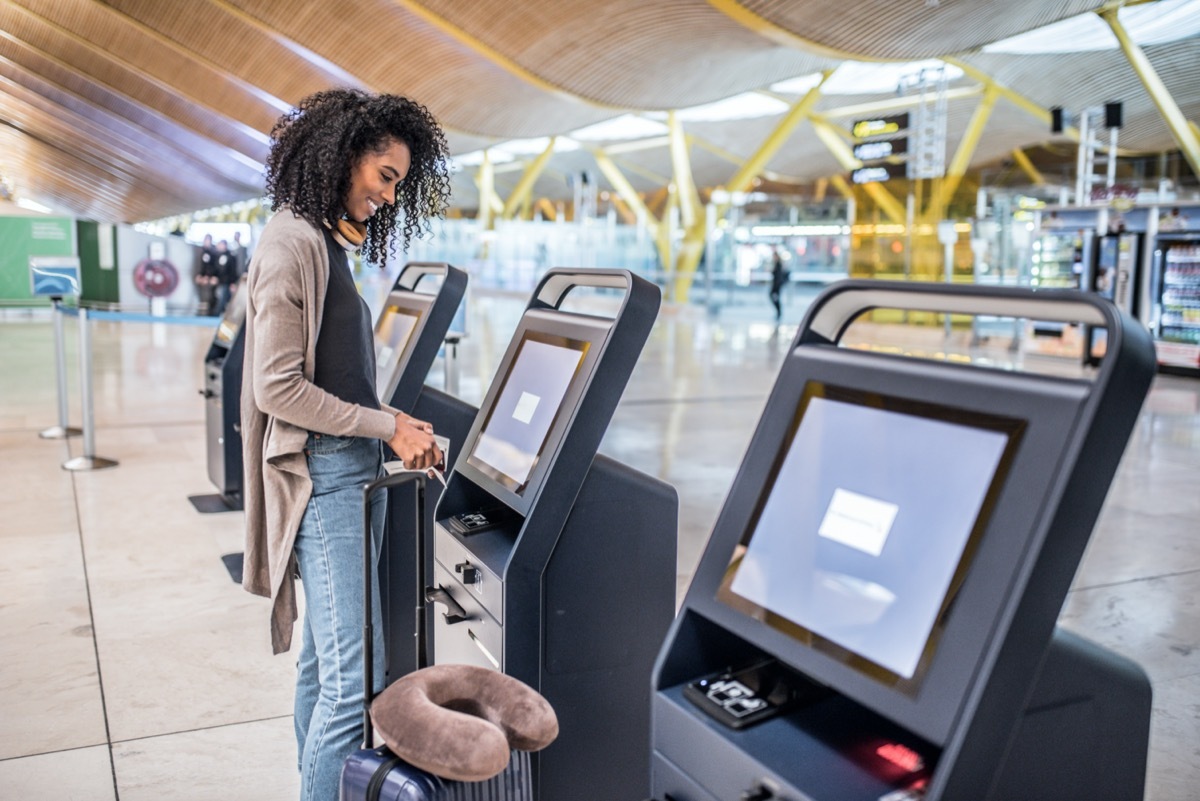woman checks into her flight on a kiosk