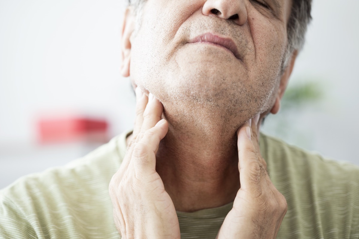 Old man feeling pain in the throat or thyroid