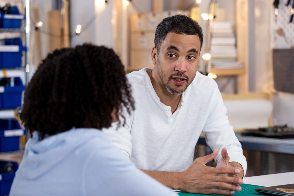 serious father talking to his daughter in a classroom setting