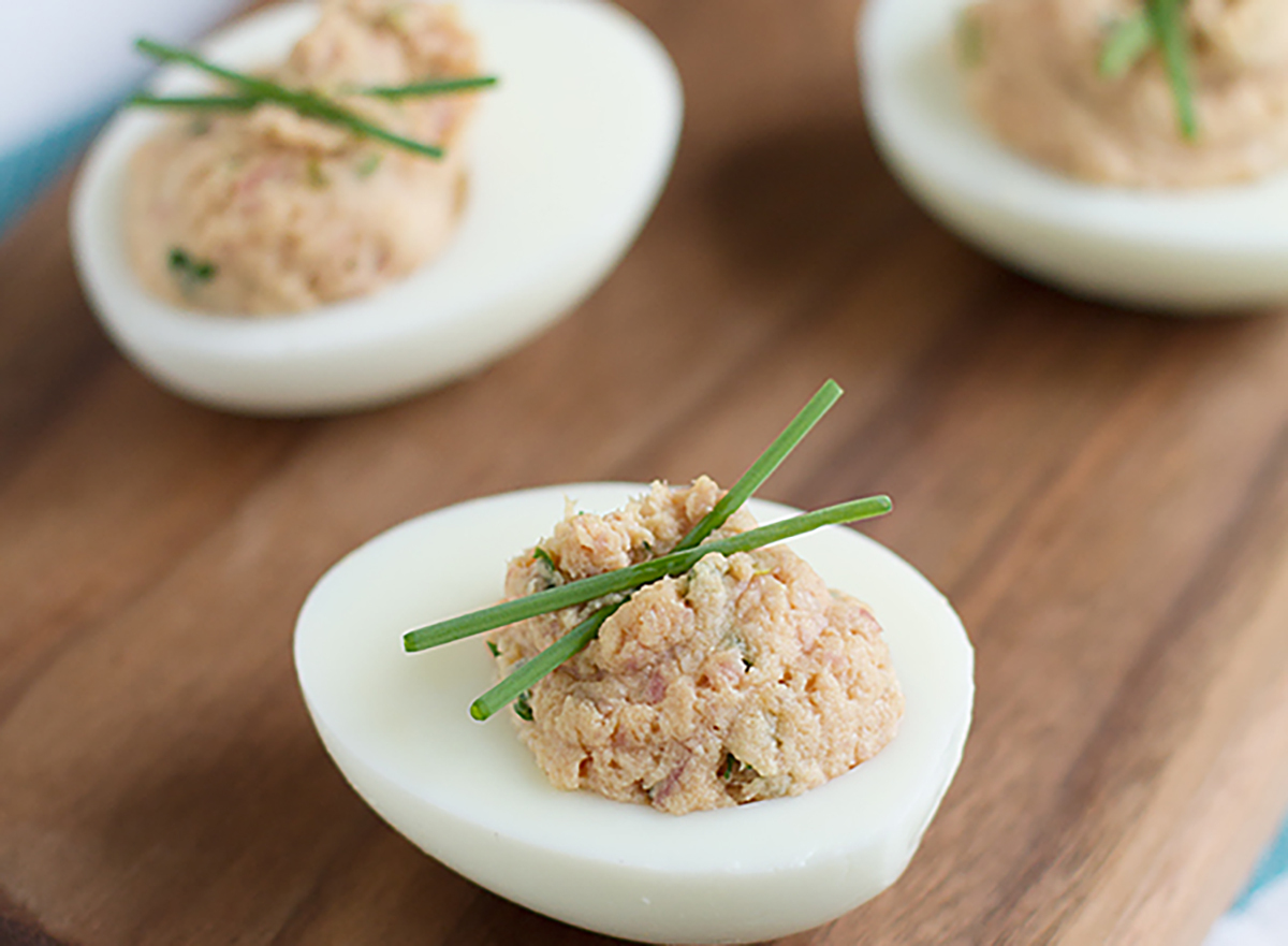 deviled eggs with ham on wooden board