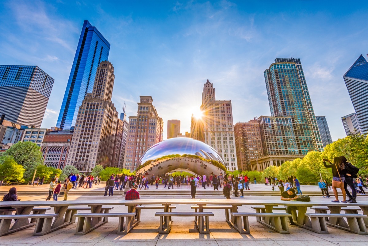 CHICAGO - ILLINOIS: MAY 9, 2018: Tourists visit Cloud Gate in Millennium Park in the late afternoon.