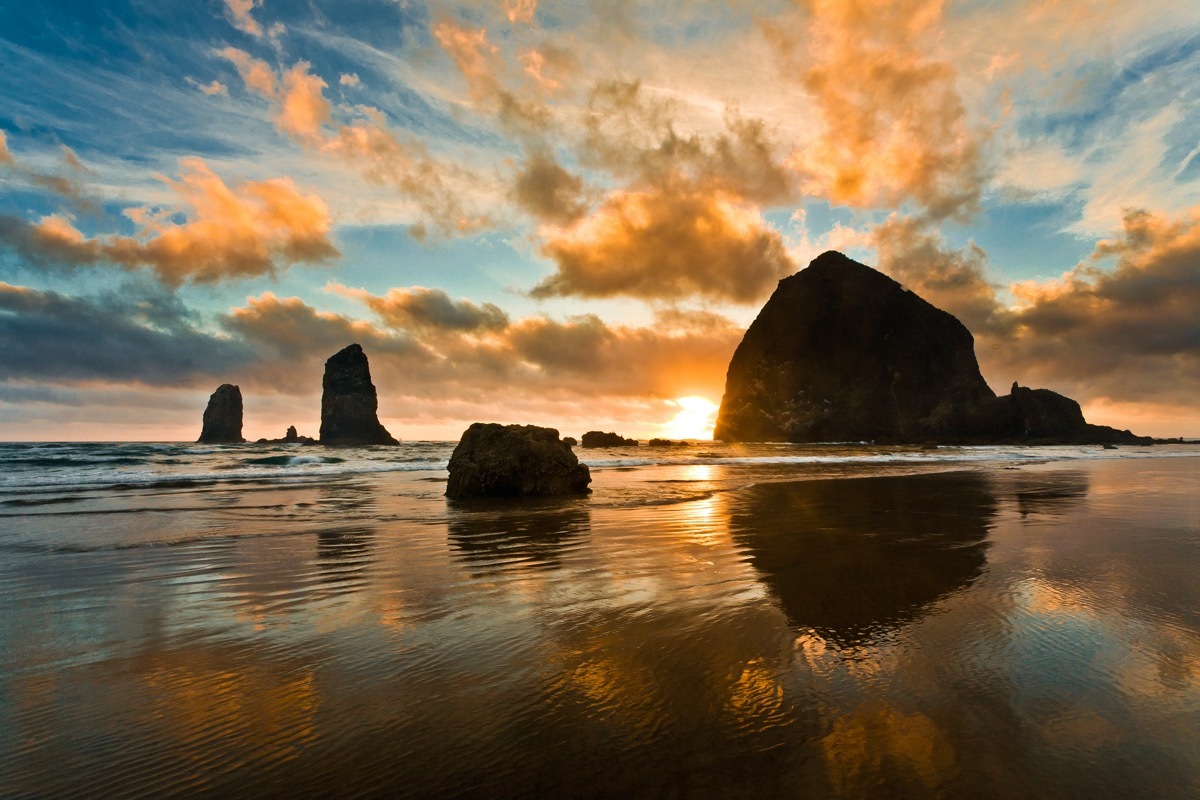 sunset over boulders on a beach