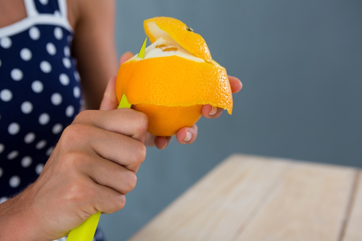 woman peeling orange