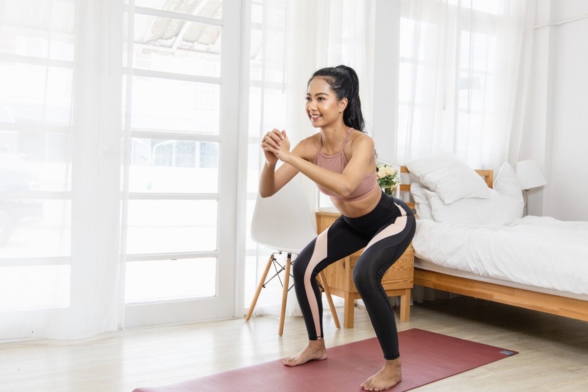 Woman Doing Body Weight Squats in her bedroom