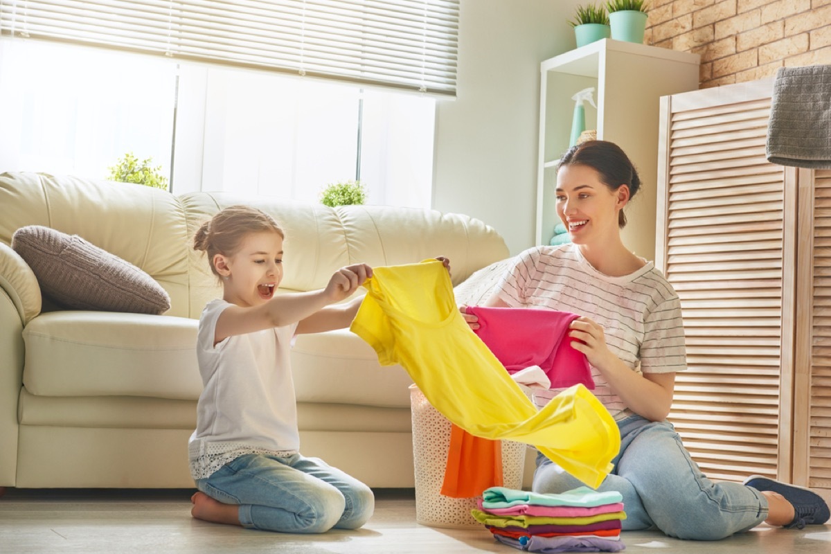young girl and mother folding laundry, skills parents should teach kids