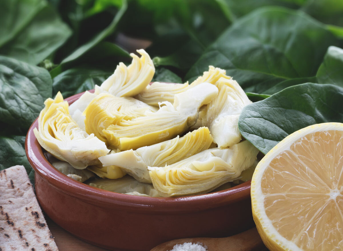 Artichoke hearts in bowl with half lemon