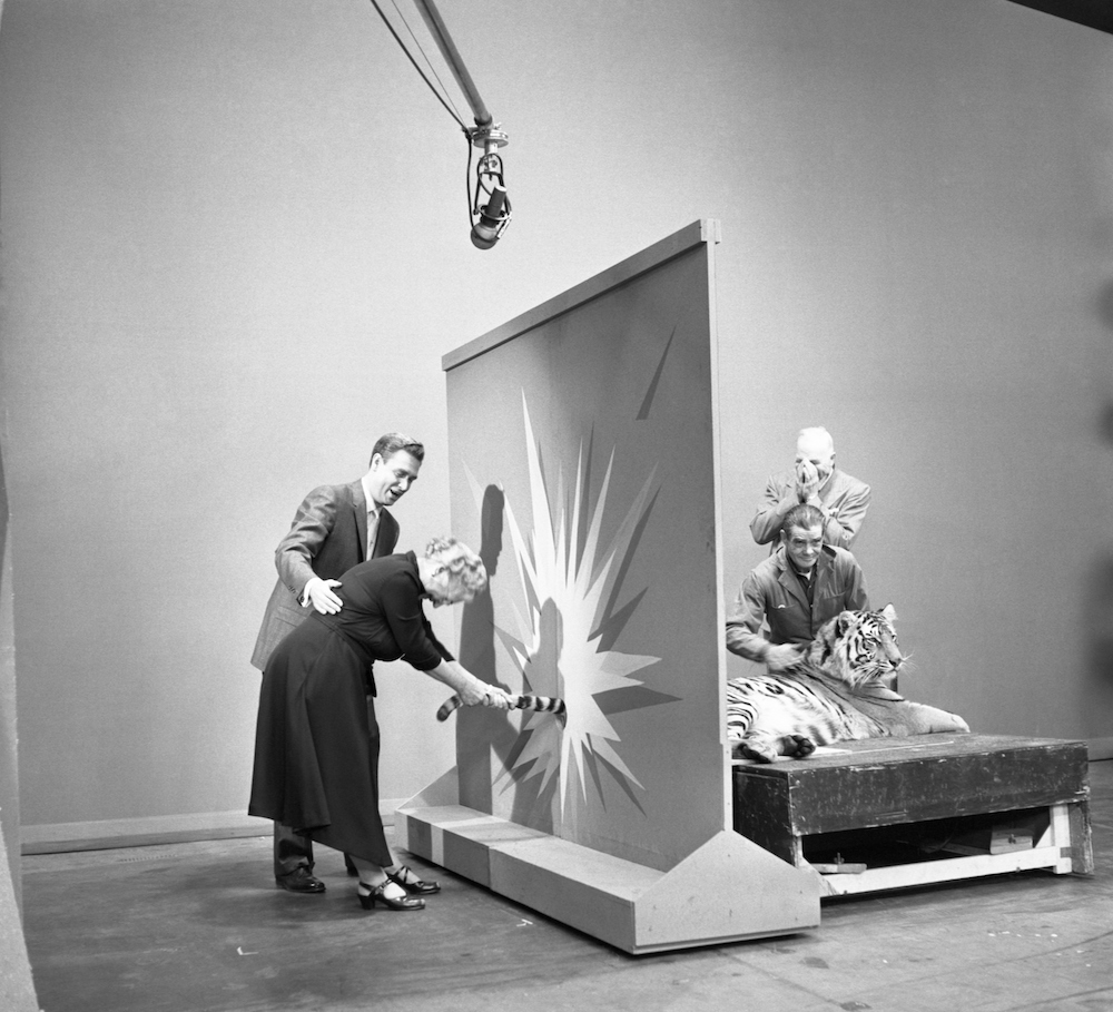 Bob Barker with a contestant holding a tiger's tail on