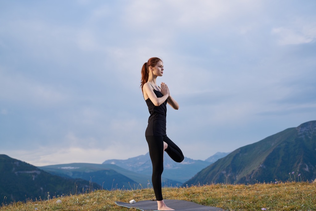 Beautiful woman doing yoga for better health and not getting sick at work