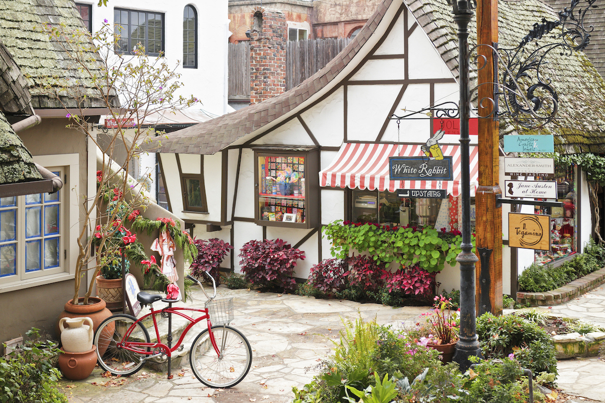 A streetscape in Carmel-by-the-Sea featuring a retail shop housed in a typical fairytale cottage - style architecture.