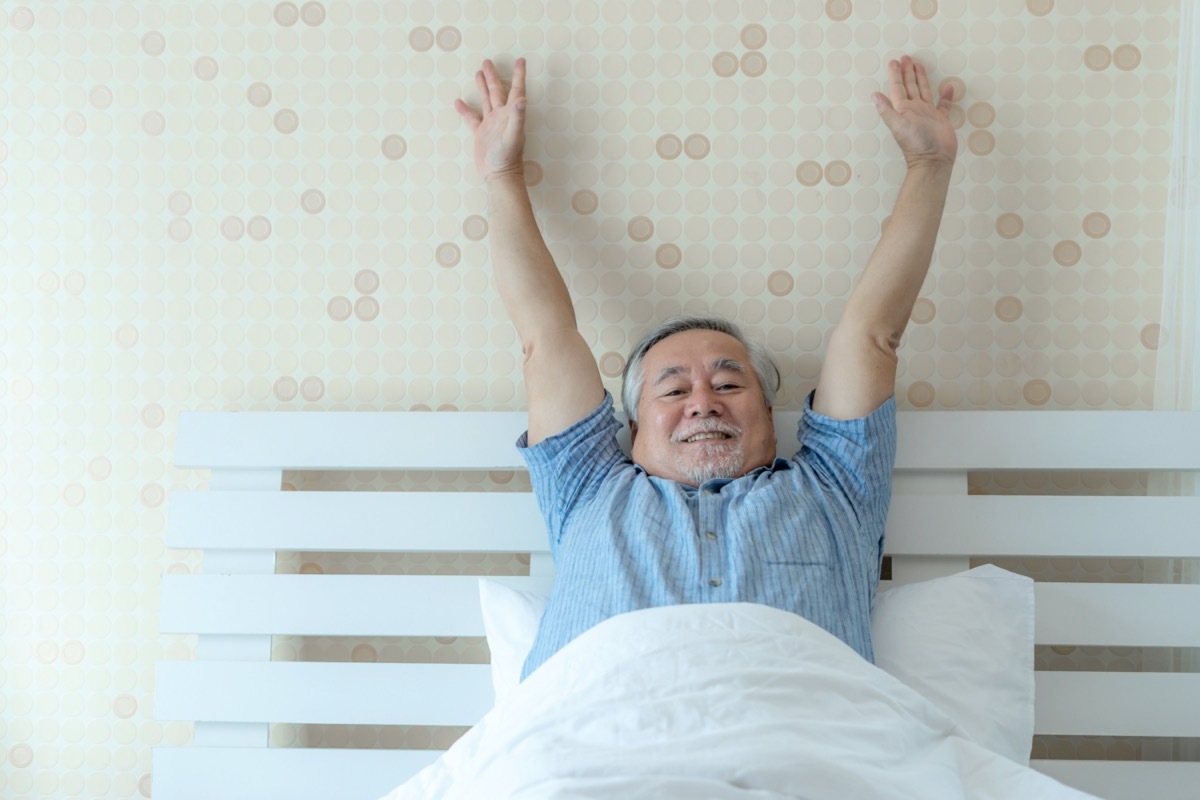 happy senior man good health wake up in the morning with joy on his bedroom 