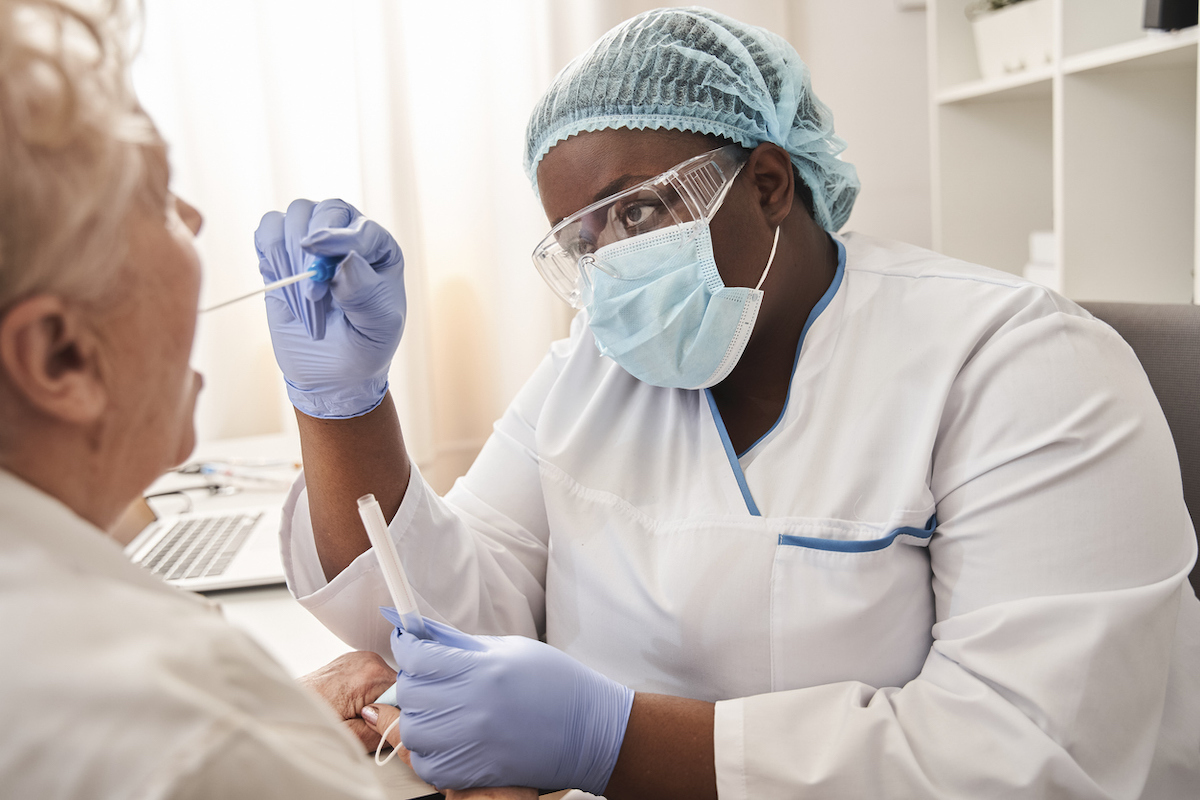 Medical worker taking a swab for coronavirus sample from potentially infected woman