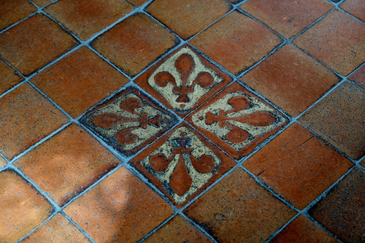 brown tile floor with blue green fleur de lis stencils