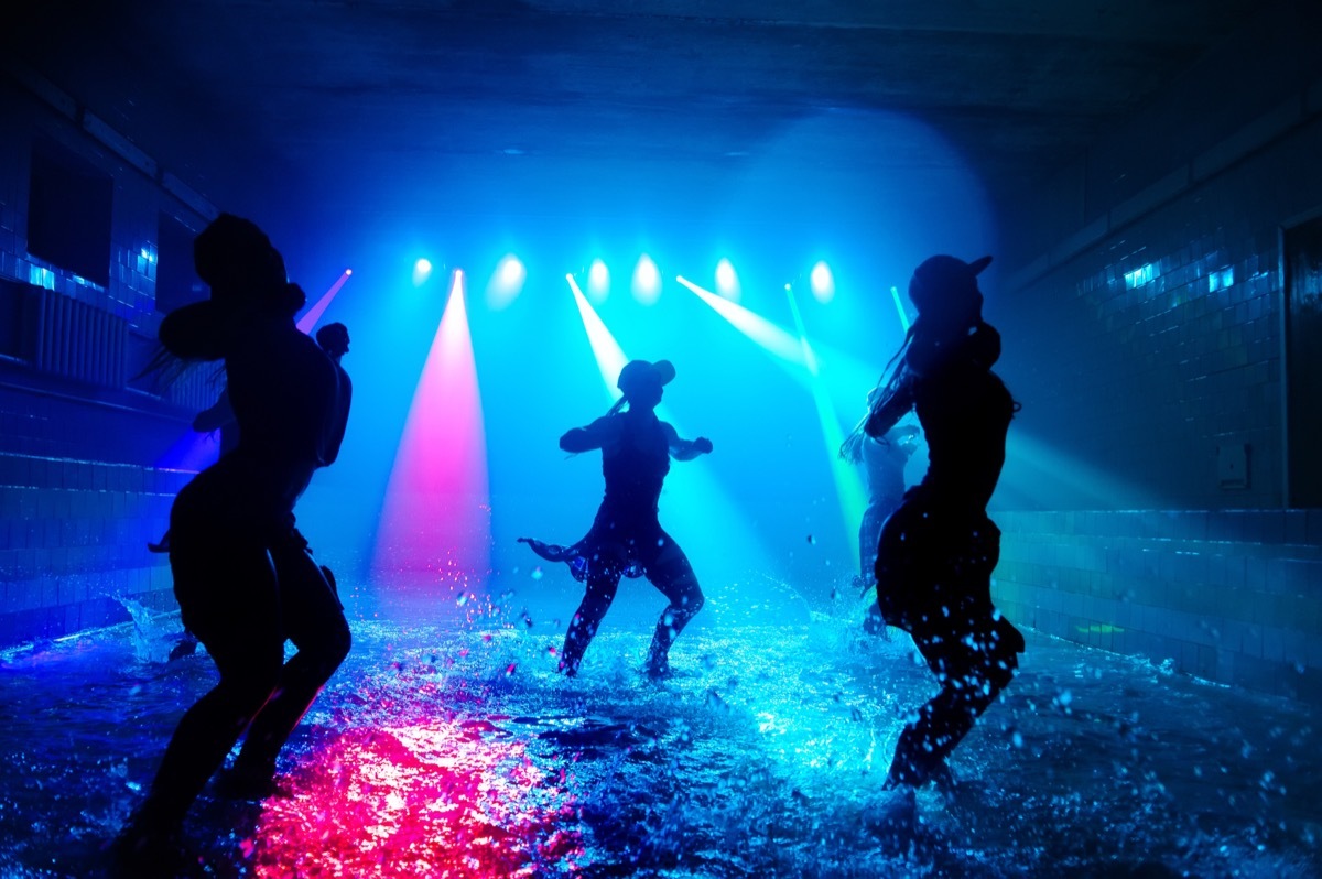 women dancing on dark stage