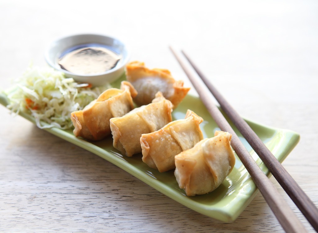 crab wonton on green plate with chopsticks