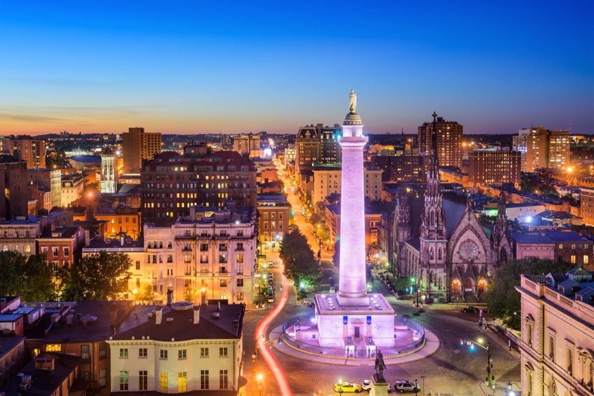 city skyline of the Washington Monument and downtown Baltimore, Maryland at dusk