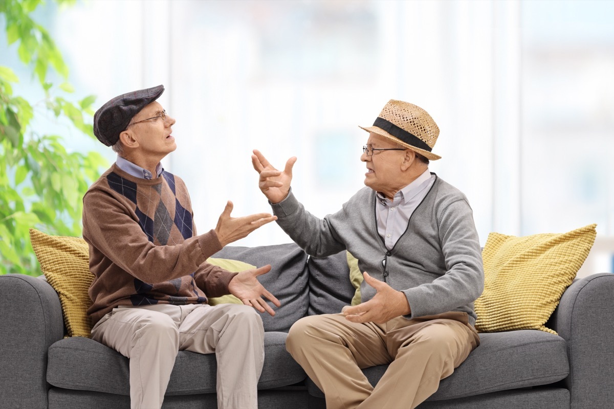 Senior men sitting on couch arguing