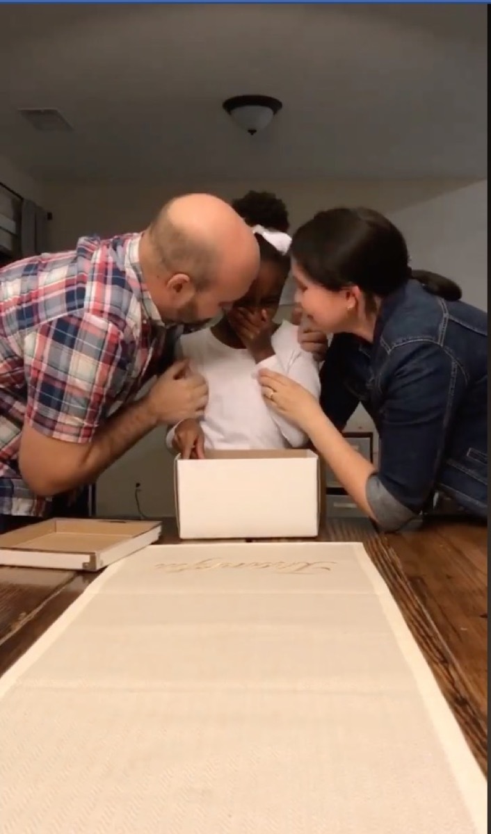 white mom and dad kissing crying young daughter