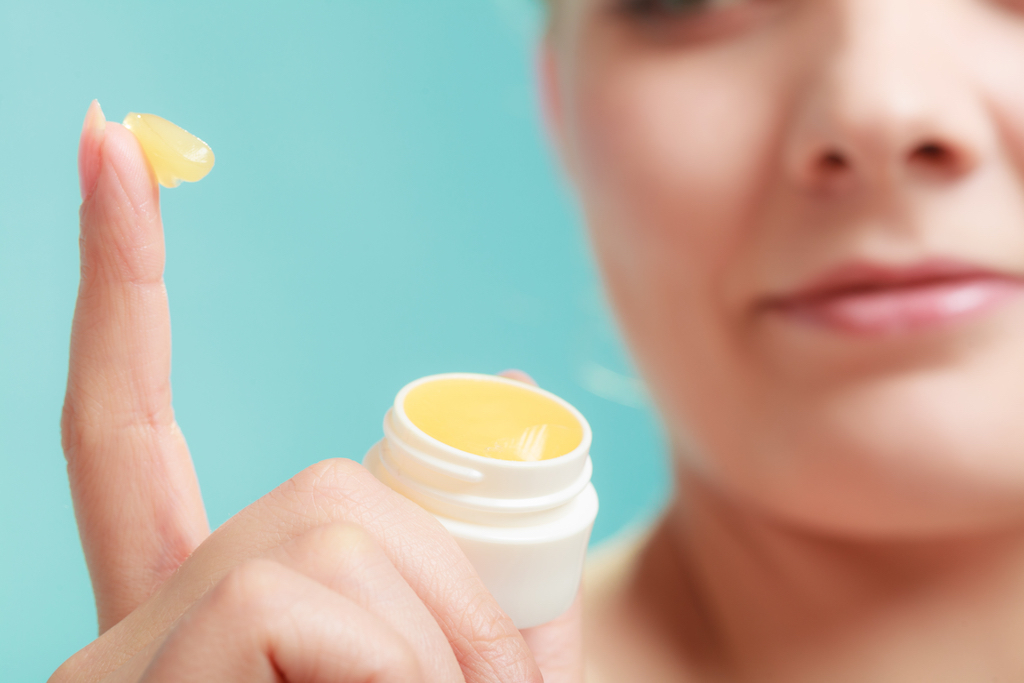 woman applying vaseline to her lips