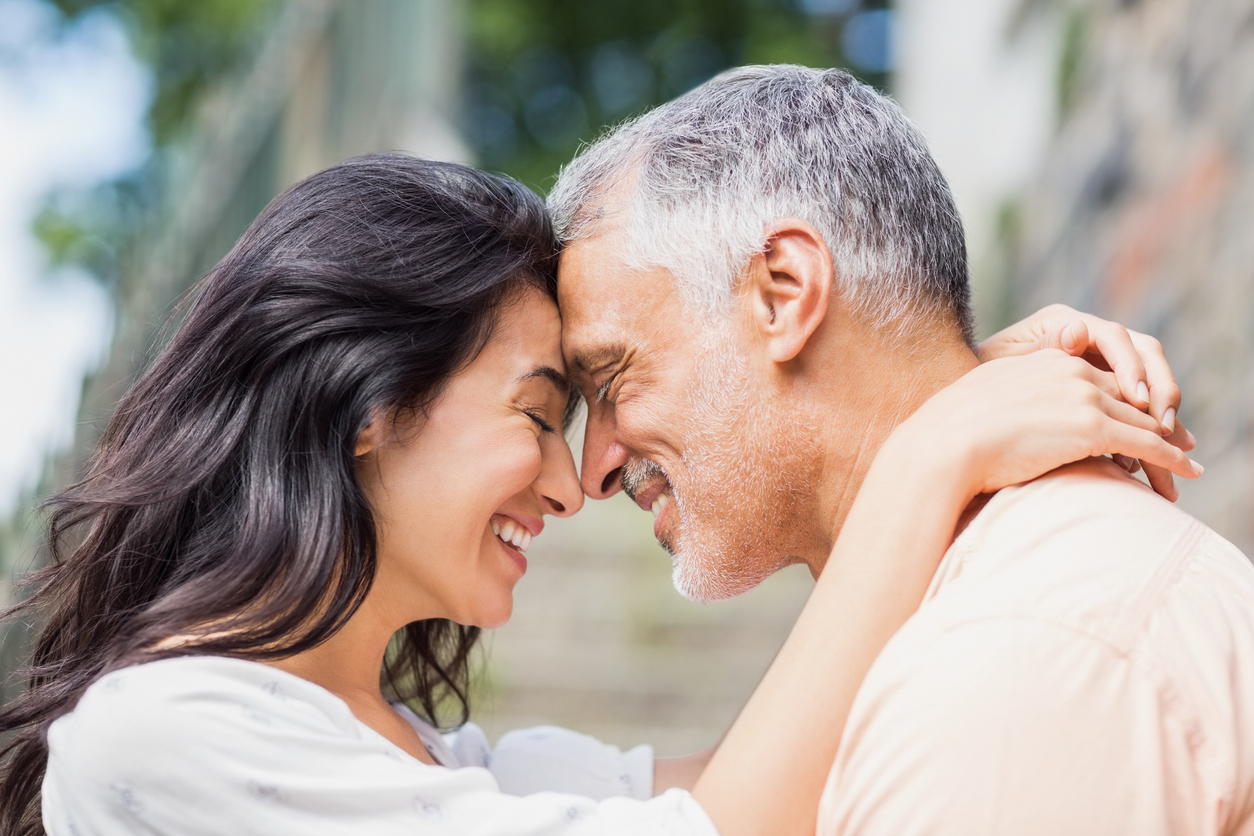 A younger woman hugging her older male partner