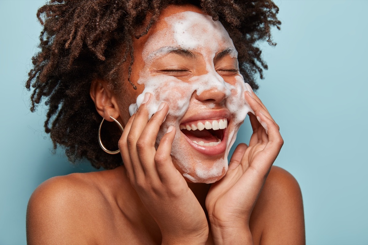 Woman putting on skin cleanser. 