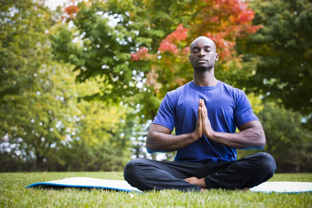 man meditating in the lawn self-care tips