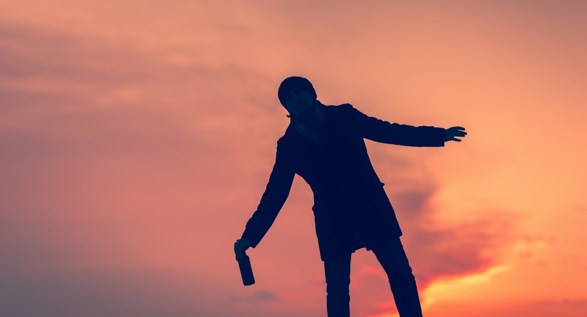 drunk young man is walking staggering down the street