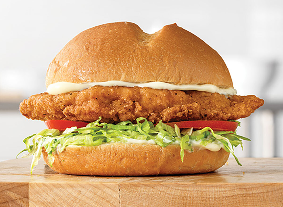 arbys crispy chicken sandwich on wooden board
